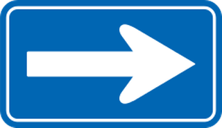 Official Japanese one-way sign: horizontal blue rectangle with a white arrow pointing right